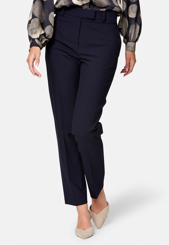 Georgiana, the tailored slim trouser. Cut in worsted navy bi-stretch suiting, it sits on the natural waist with a gently tapered leg falling to a neat ankle length. Finished with pressed creases, belt loops, side seam pockets and back welt pockets. Wear with the Darcie blazer for the coordinating suit, and style with the Anastasia pussy-bow blouse.