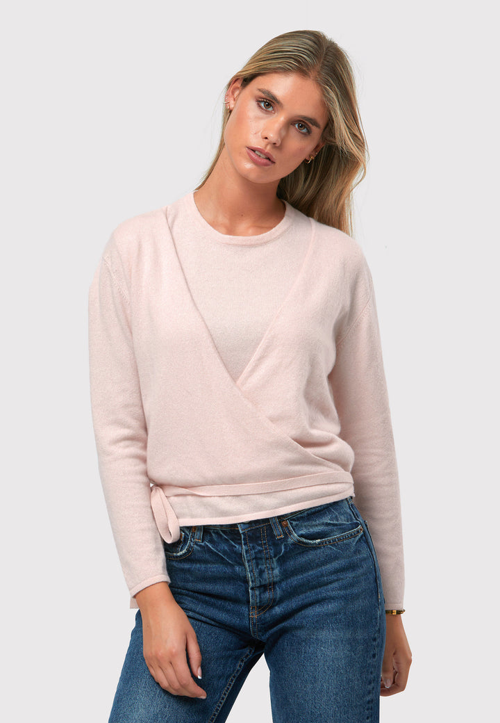 The Siena Petal Pink Cashmere Ballet Wrap is a versatile cardigan designed with a true wrap style. It features full-length sleeves and offers multiple styling options. You can wear it to the front with a V-neckline or to the back with a high neckline and a V-back detail. Made from luxurious cashmere, this wrap can also be layered over the matching Mariena Sleeveless Top for a coordinated and chic ensemble. Embrace the versatility and timeless elegance of the Ballet Wrap.