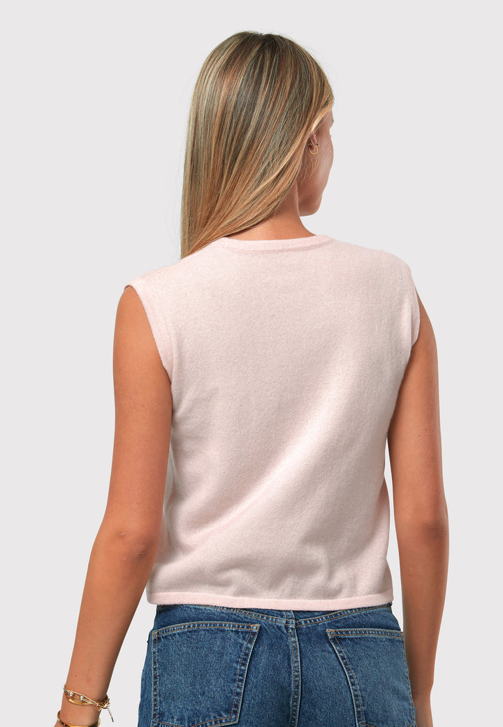 The Marlena Petal Pink Cashmere Sweater-Vest is a sleeveless round neck top that offers versatile styling options. Wear it as a simple underpinning for the matching ballet wrap to complete a coordinated look. Alternatively, layer it as a sweater vest over your favorite crisp white shirts for a stylish and contemporary outfit. Made from luxurious cashmere, the Marlena Sweater-Vest adds an extra layer of comfort and sophistication to your wardrobe.