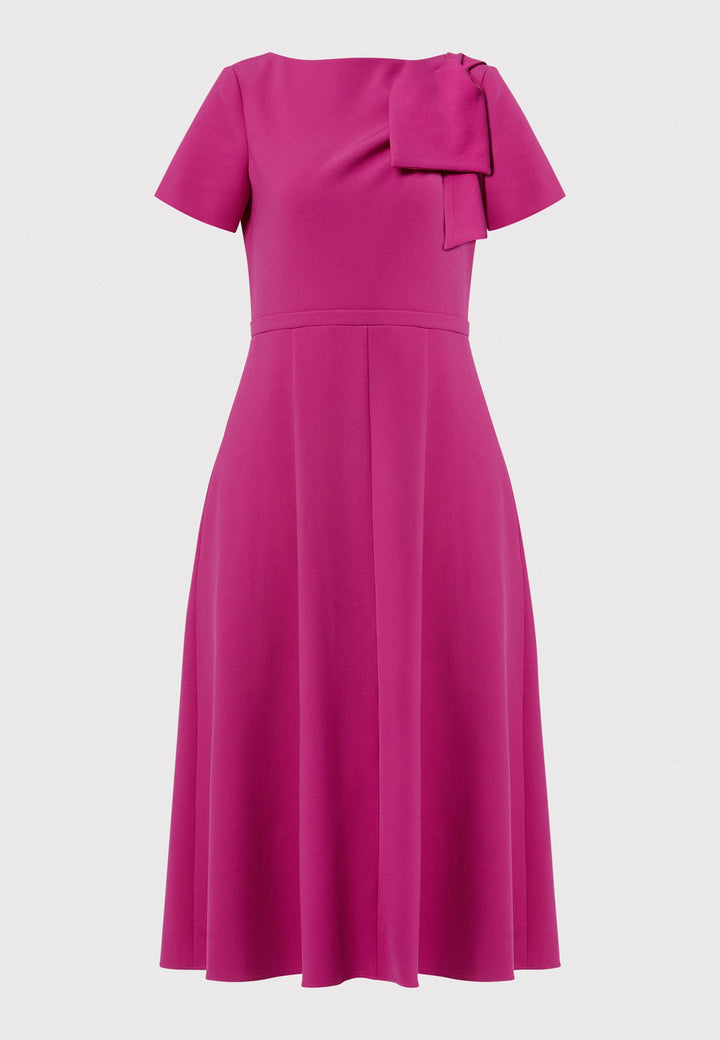 Introducing the Laoise pink dress, a refined statement piece for special occasions. Featuring short sleeves, a fitted bodice, and an elegant shoulder bow detail, this dress has a flattering A-line shape with a cascading paneled skirt. Designed with side seam pockets and a back zip for ease, it combines comfort and sophistication, making it perfect for races, weddings and formal events.