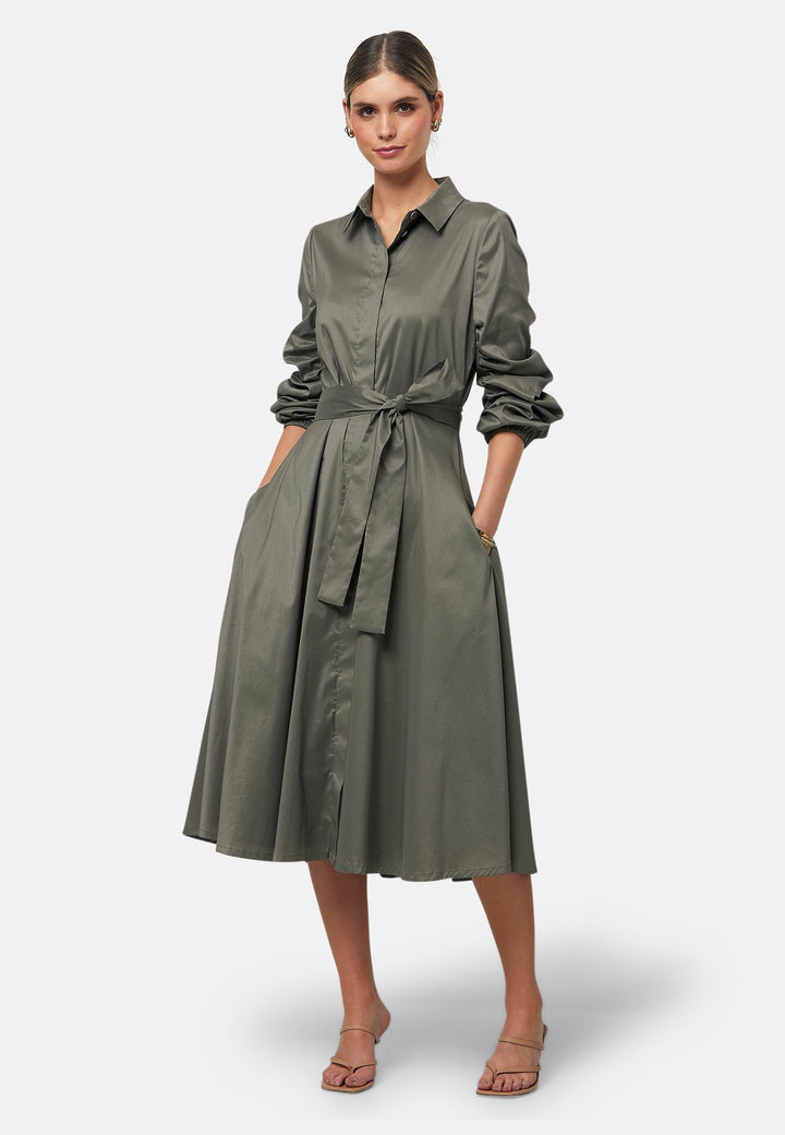 The Leah Olive midi shirt dress combines classic tailoring with a feminine touch. Featuring a button-down front and ruched three-quarter length sleeves, it offers versatility and style. The detachable tie belt cinches the waist, while the gently flared skirt provides a flattering silhouette with essential side seam pockets.