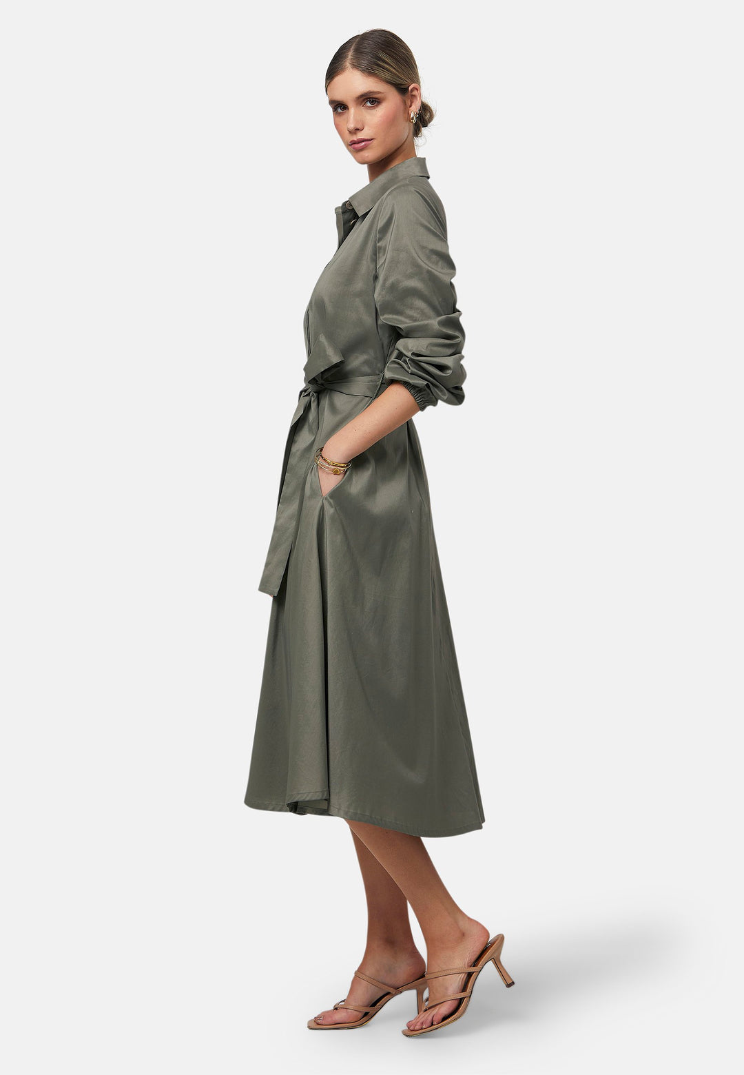 The Leah Olive midi shirt dress combines classic tailoring with a feminine touch. Featuring a button-down front and ruched three-quarter length sleeves, it offers versatility and style. The detachable tie belt cinches the waist, while the gently flared skirt provides a flattering silhouette with essential side seam pockets.