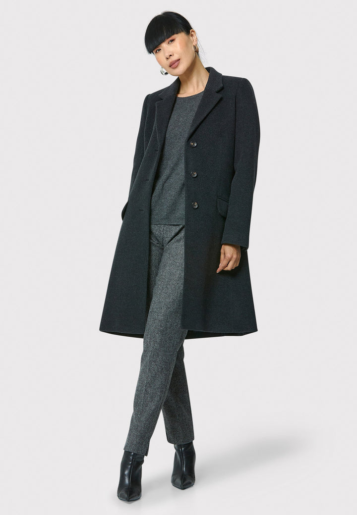 The Leighton charcoal grey coat is crafted from a luxurious wool and cashmere melton blend. Expertly crafted, this knee-length coat offers both warmth and sophistication. Drawing inspiration from refined men's tailoring, it showcases a tidy collar and revere design. With a three-button finish and practical pockets, this coat effortlessly combines functionality with style. Elevate your outerwear collection with this versatile and classic piece that will ensure you stay chic and cozy throughout the winter sea