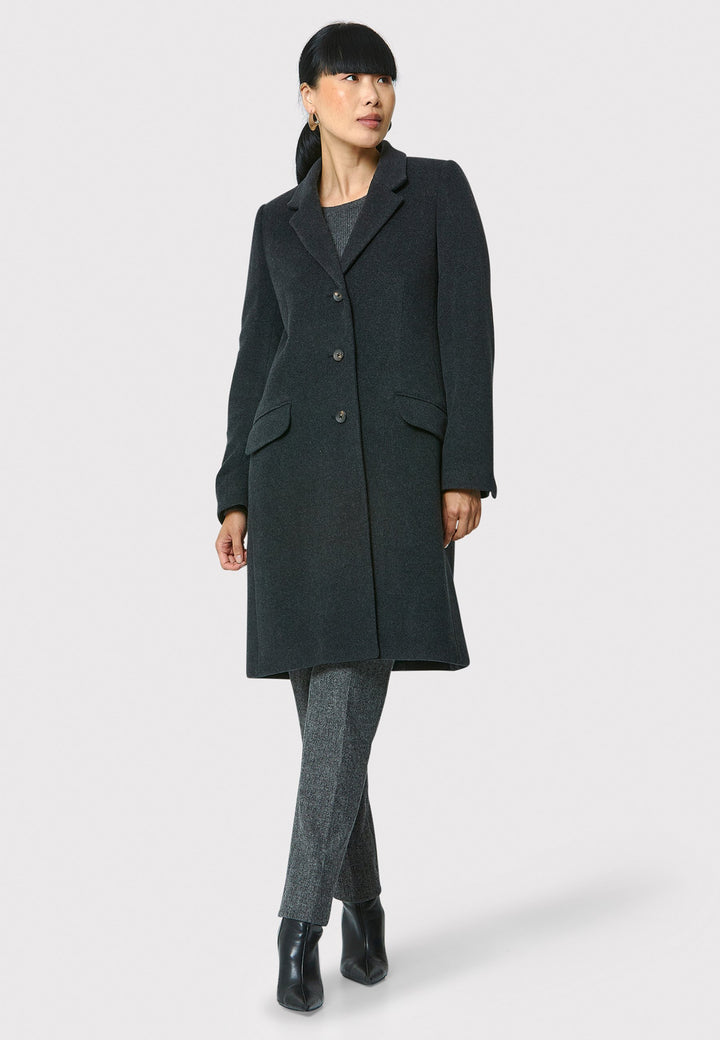 The Leighton charcoal grey coat is crafted from a luxurious wool and cashmere melton blend. Expertly crafted, this knee-length coat offers both warmth and sophistication. Drawing inspiration from refined men's tailoring, it showcases a tidy collar and revere design. With a three-button finish and practical pockets, this coat effortlessly combines functionality with style. Elevate your outerwear collection with this versatile and classic piece that will ensure you stay chic and cozy throughout the winter sea