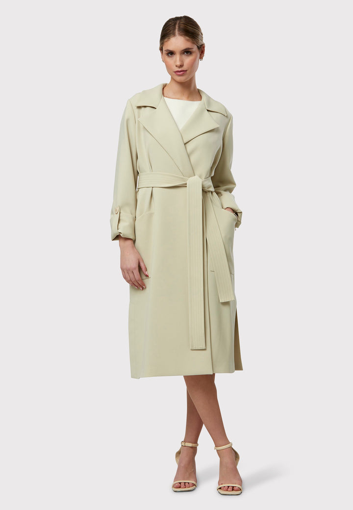 Lydiah captures the essence of sophisticated simplicity with its elegant design. This fluid trench coat features a neutral bone hue that radiates timeless appeal. It comes with a meticulously row-stitched, detachable belt that adds a touch of refinement, allowing you the flexibility to cinch it at the waist or wear it open for a relaxed look.