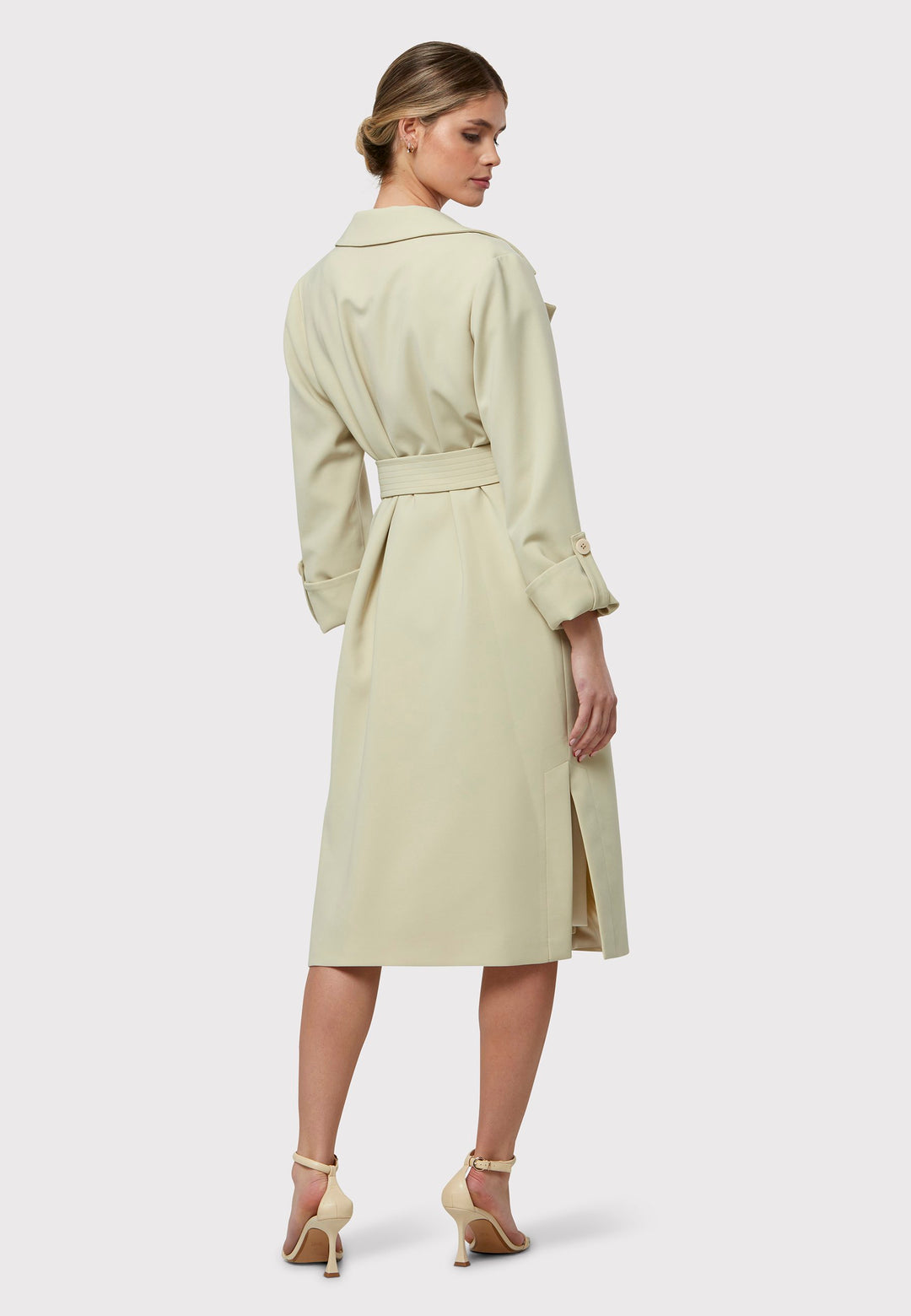 Lydiah captures the essence of sophisticated simplicity with its elegant design. This fluid trench coat features a neutral bone hue that radiates timeless appeal. It comes with a meticulously row-stitched, detachable belt that adds a touch of refinement, allowing you the flexibility to cinch it at the waist or wear it open for a relaxed look.