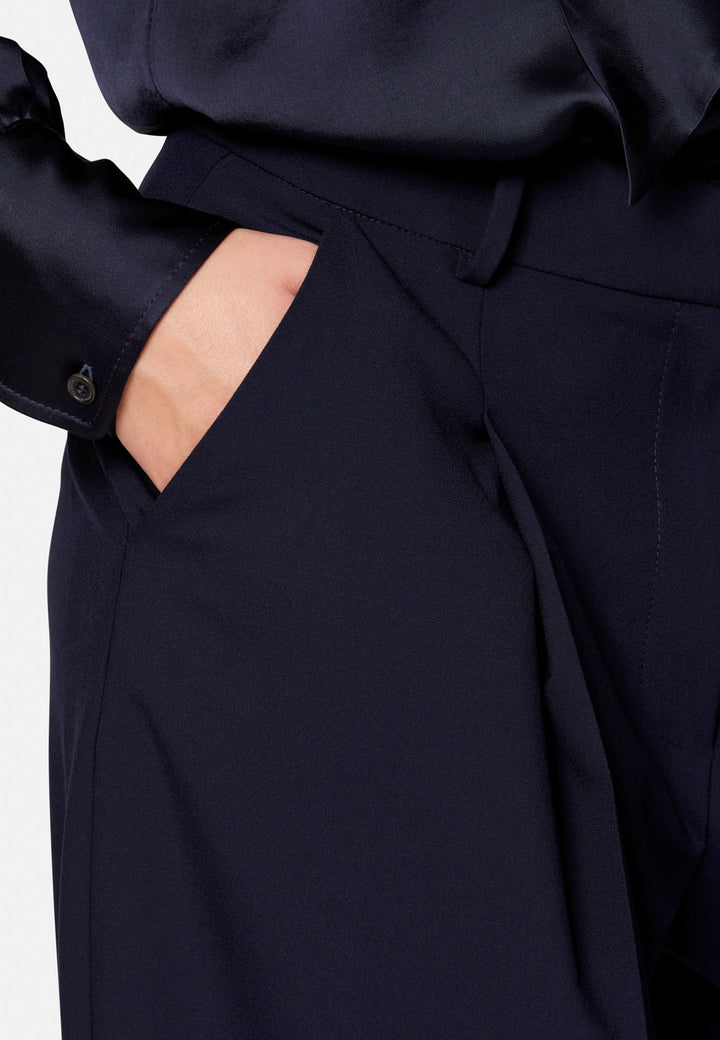 Lyra, the modern wide-leg trouser. Tailored with a natural waist, soft front pleats and sharp pressed creases. Full-length and fluid for an elongating line, with side pockets, belt loops and neat back welt pockets. Wear with the Darcie blazer for the coordinating suit, or dress down with a simple knit.
