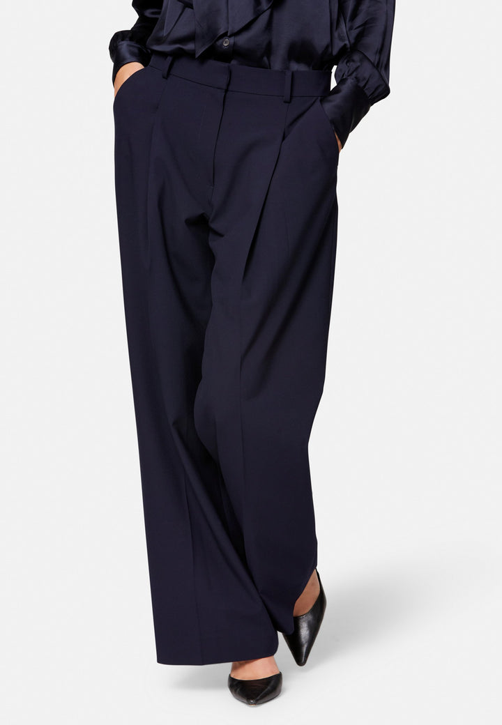 Lyra, the modern wide-leg trouser. Tailored with a natural waist, soft front pleats and sharp pressed creases. Full-length and fluid for an elongating line, with side pockets, belt loops and neat back welt pockets. Wear with the Darcie blazer for the coordinating suit, or dress down with a simple knit.