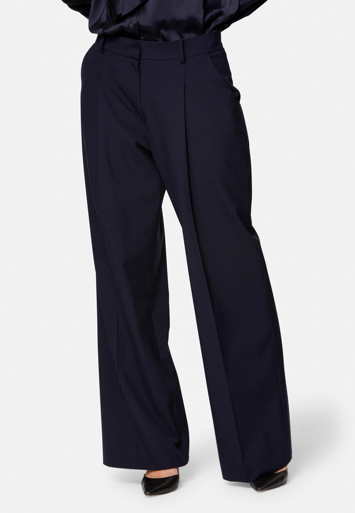 Lyra, the modern wide-leg trouser. Tailored with a natural waist, soft front pleats and sharp pressed creases. Full-length and fluid for an elongating line, with side pockets, belt loops and neat back welt pockets. Wear with the Darcie blazer for the coordinating suit, or dress down with a simple knit.