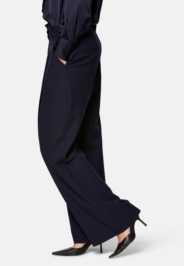 Lyra, the modern wide-leg trouser. Tailored with a natural waist, soft front pleats and sharp pressed creases. Full-length and fluid for an elongating line, with side pockets, belt loops and neat back welt pockets. Wear with the Darcie blazer for the coordinating suit, or dress down with a simple knit.