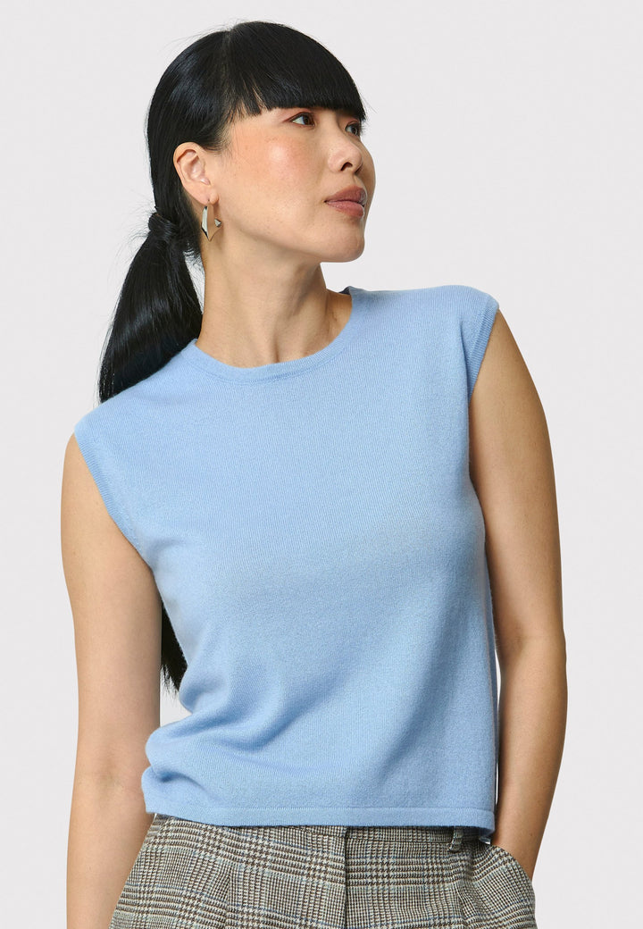 The Marlena Porcelain Blue Cashmere Sweater-Vest is a sleeveless, round-neck top that offers versatile styling options. Wear it as a simple underpinning for the matching Greta cardigan to complete a coordinated look. Alternatively, layer it as a sweater vest over your favorite crisp white shirts for a stylish and contemporary outfit. Made from luxurious cashmere, the Marlena Sweater-Vest adds an extra layer of comfort and sophistication to your wardrobe.