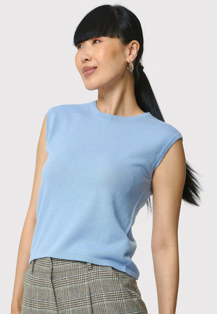 The Marlena Porcelain Blue Cashmere Sweater-Vest is a sleeveless, round-neck top that offers versatile styling options. Wear it as a simple underpinning for the matching Greta cardigan to complete a coordinated look. Alternatively, layer it as a sweater vest over your favorite crisp white shirts for a stylish and contemporary outfit. Made from luxurious cashmere, the Marlena Sweater-Vest adds an extra layer of comfort and sophistication to your wardrobe.