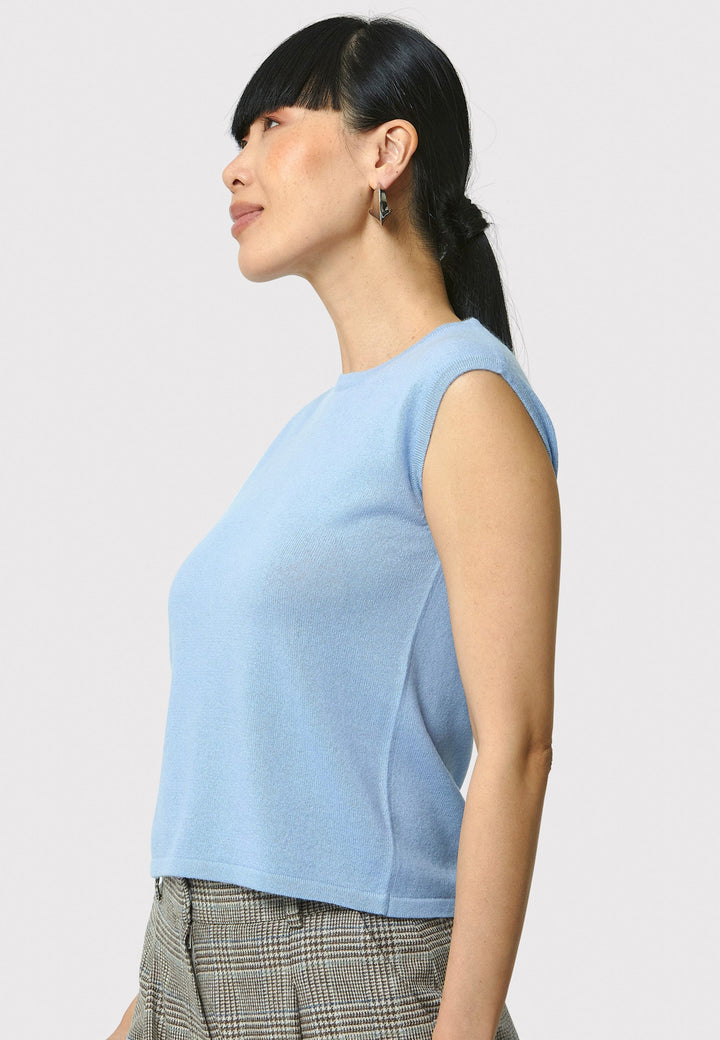 The Marlena Porcelain Blue Cashmere Sweater-Vest is a sleeveless, round-neck top that offers versatile styling options. Wear it as a simple underpinning for the matching Greta cardigan to complete a coordinated look. Alternatively, layer it as a sweater vest over your favorite crisp white shirts for a stylish and contemporary outfit. Made from luxurious cashmere, the Marlena Sweater-Vest adds an extra layer of comfort and sophistication to your wardrobe.