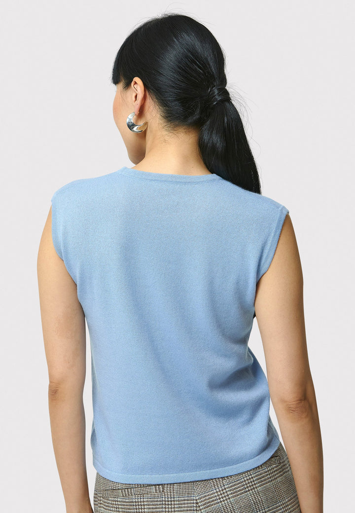 The Marlena Porcelain Blue Cashmere Sweater-Vest is a sleeveless, round-neck top that offers versatile styling options. Wear it as a simple underpinning for the matching Greta cardigan to complete a coordinated look. Alternatively, layer it as a sweater vest over your favorite crisp white shirts for a stylish and contemporary outfit. Made from luxurious cashmere, the Marlena Sweater-Vest adds an extra layer of comfort and sophistication to your wardrobe.