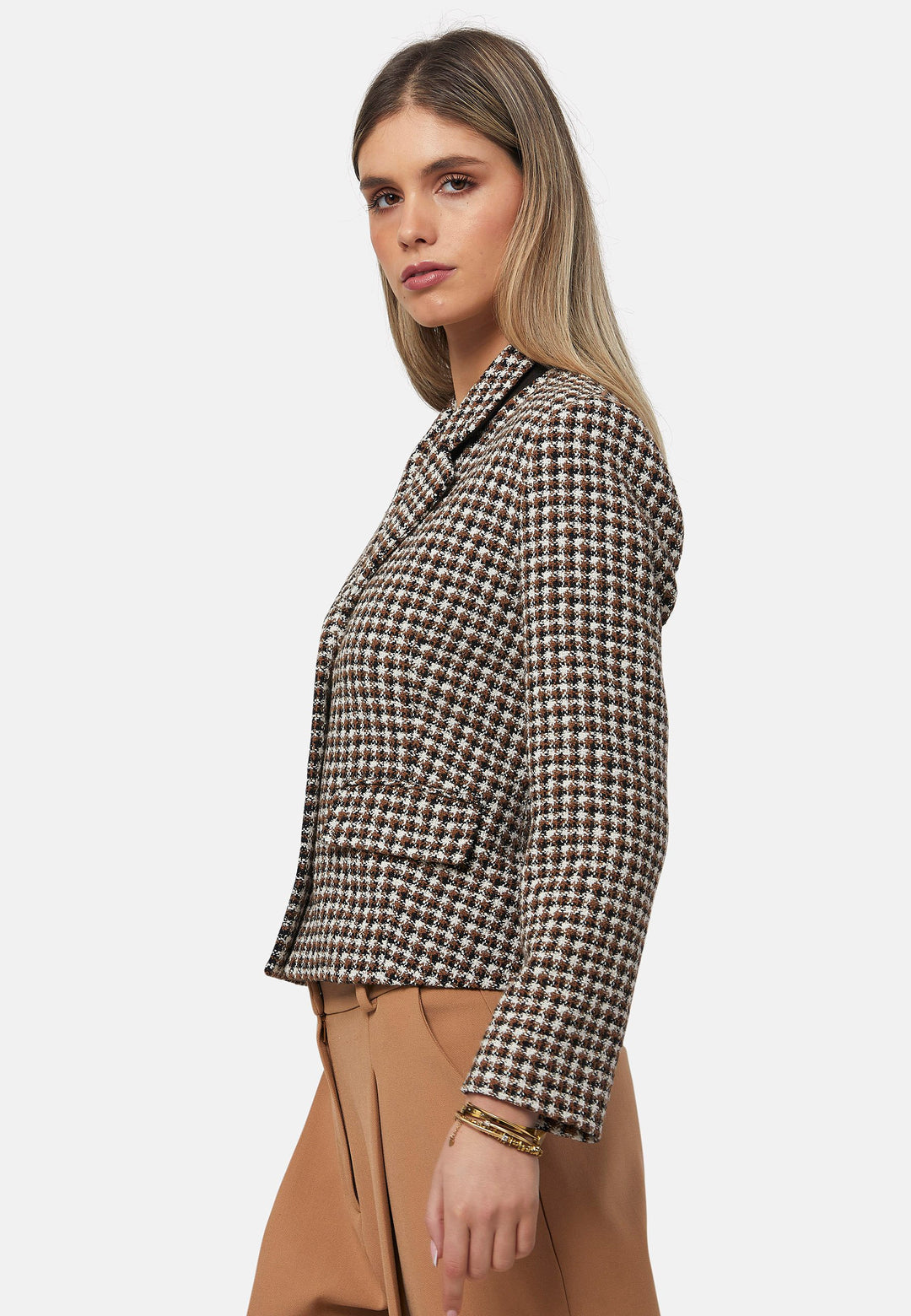 This bouclé tailored blazer features a classic houndstooth pattern in earthy brown, black, and white tones. Designed with a structured fit, it includes a notched lapel, three-button front closure, and flap pockets for a timeless look. Perfect for elevating both office and casual outfits.