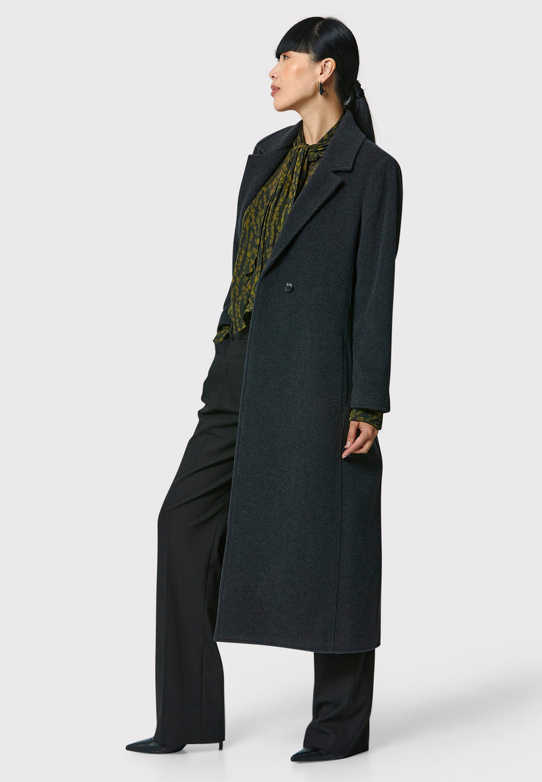 The Mikaela Charcoal Grey Coat, crafted from a luxurious blend of wool and cashmere, offers both style and versatility. This long duster coat features a classic collar and revere, button closure and practical side seam slits. Wear it straight for a relaxed silhouette, or cinch the waist with the matching self-fabric belt for a more defined shape. Complete with side seam pockets, this coat is a refined addition to your outerwear collection.