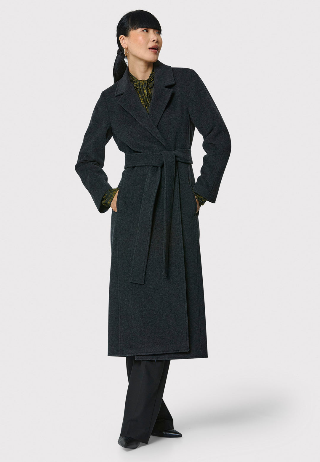 The Mikaela Charcoal Grey Coat, crafted from a luxurious blend of wool and cashmere, offers both style and versatility. This long duster coat features a classic collar and revere, button closure and practical side seam slits. Wear it straight for a relaxed silhouette, or cinch the waist with the matching self-fabric belt for a more defined shape. Complete with side seam pockets, this coat is a refined addition to your outerwear collection.