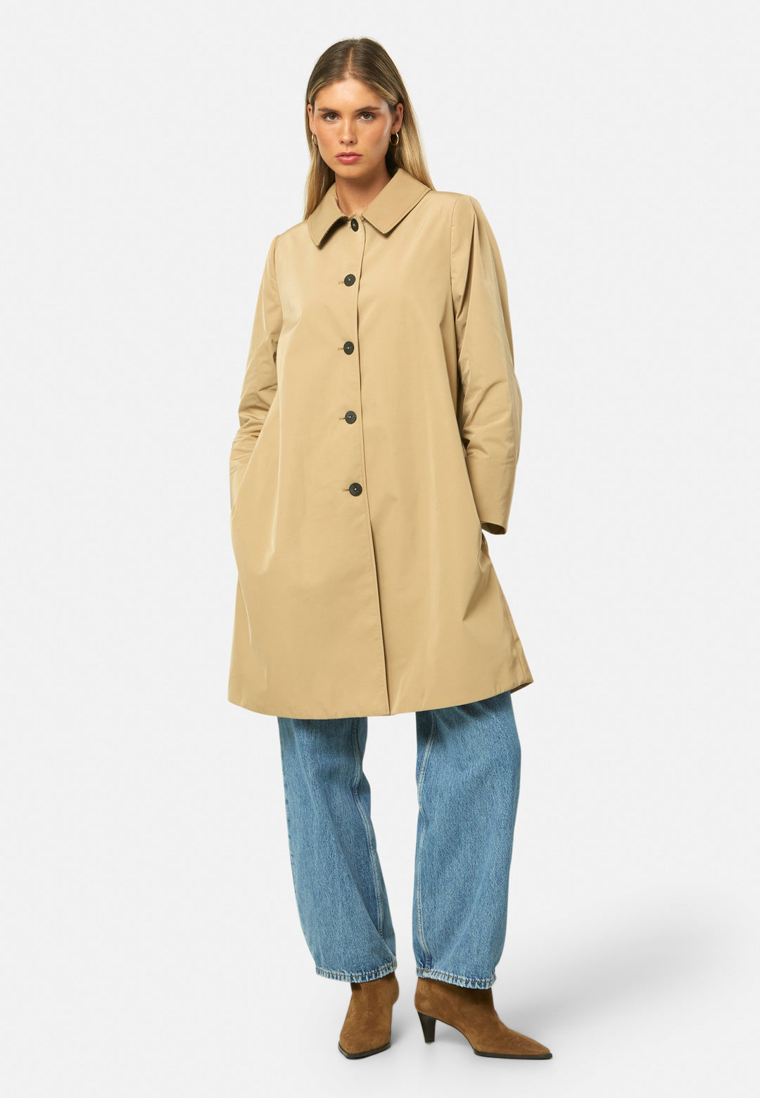 woman wearing beige mac trench coat over jeans