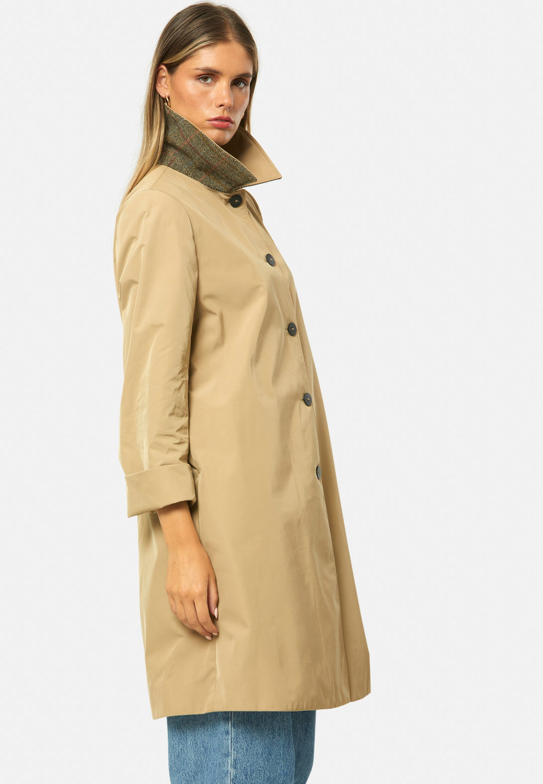 woman wearing beige mac trench coat over jeans