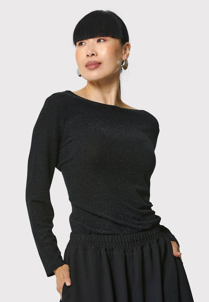 Introducing the Roxanne Black Shimmer Top, an updated version of the beloved best-selling faux-wrap top. This season's design features a beautifully draped neckline for an elegant touch. With its hip-length cut and full-length sleeves, this top combines comfort and chic style effortlessly. Crafted from a black sparkly jersey fabric, it adds a touch of glamour to any outfit. Embrace the ultimate in comfortable chic with the Roxanne Black Shimmer Top.