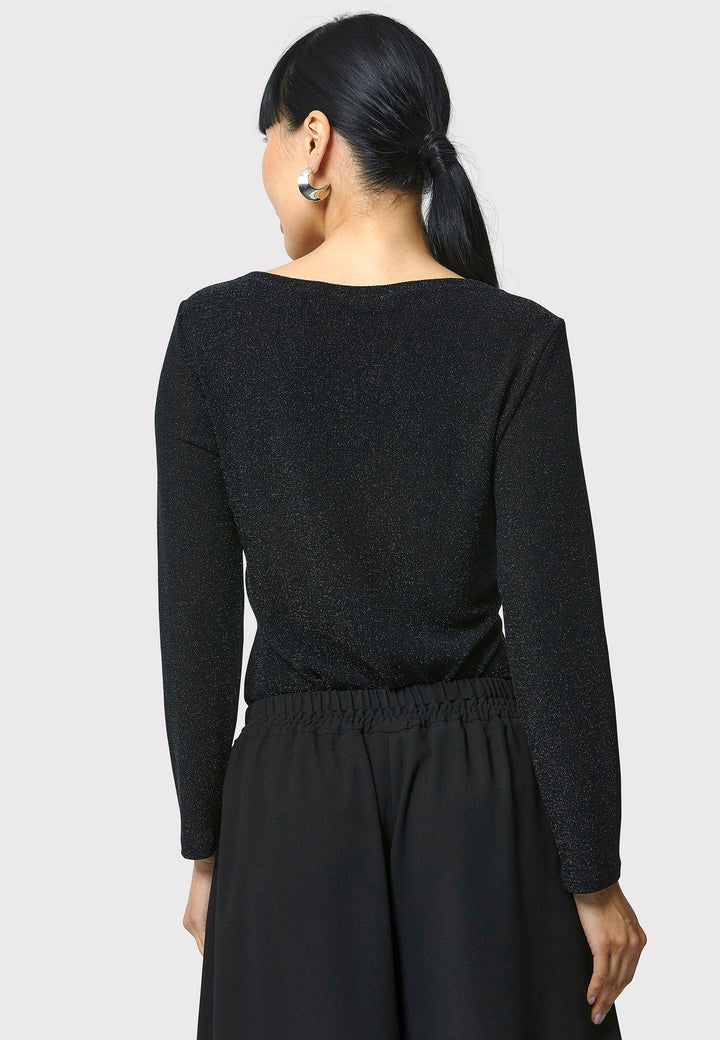 Introducing the Roxanne Black Shimmer Top, an updated version of the beloved best-selling faux-wrap top. This season's design features a beautifully draped neckline for an elegant touch. With its hip-length cut and full-length sleeves, this top combines comfort and chic style effortlessly. Crafted from a black sparkly jersey fabric, it adds a touch of glamour to any outfit. Embrace the ultimate in comfortable chic with the Roxanne Black Shimmer Top.