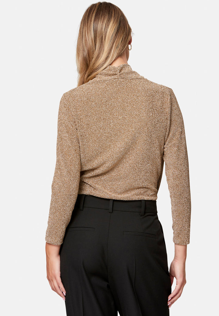 woman wearing faux wrap gold lurex top