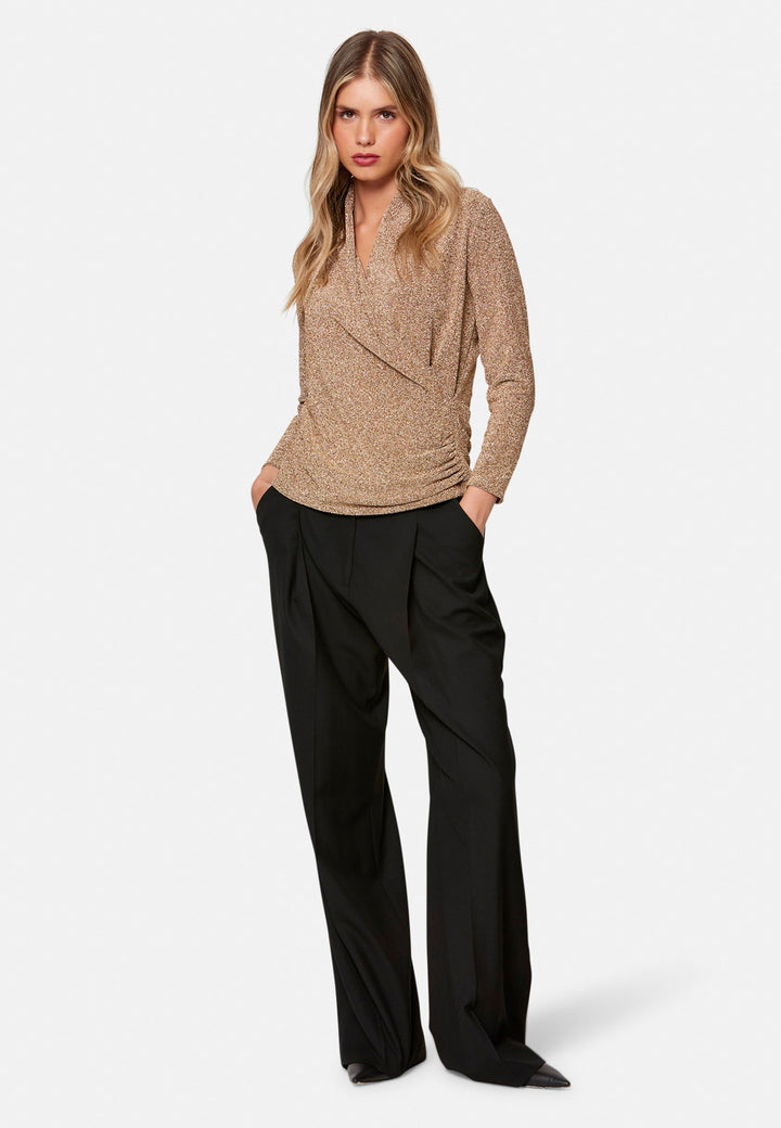 woman wearing faux wrap gold lurex top with black pants