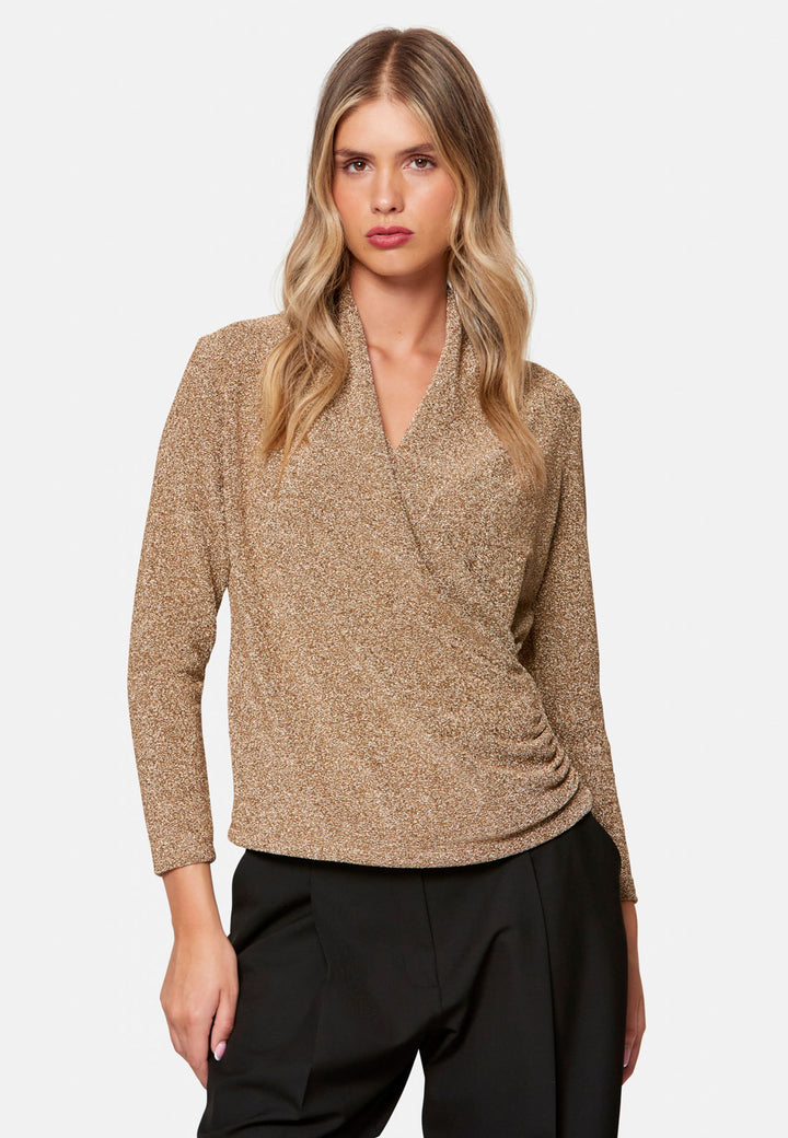 woman wearing faux wrap gold lurex top