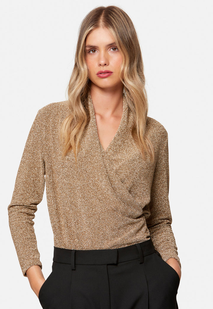 woman wearing faux wrap gold lurex top
