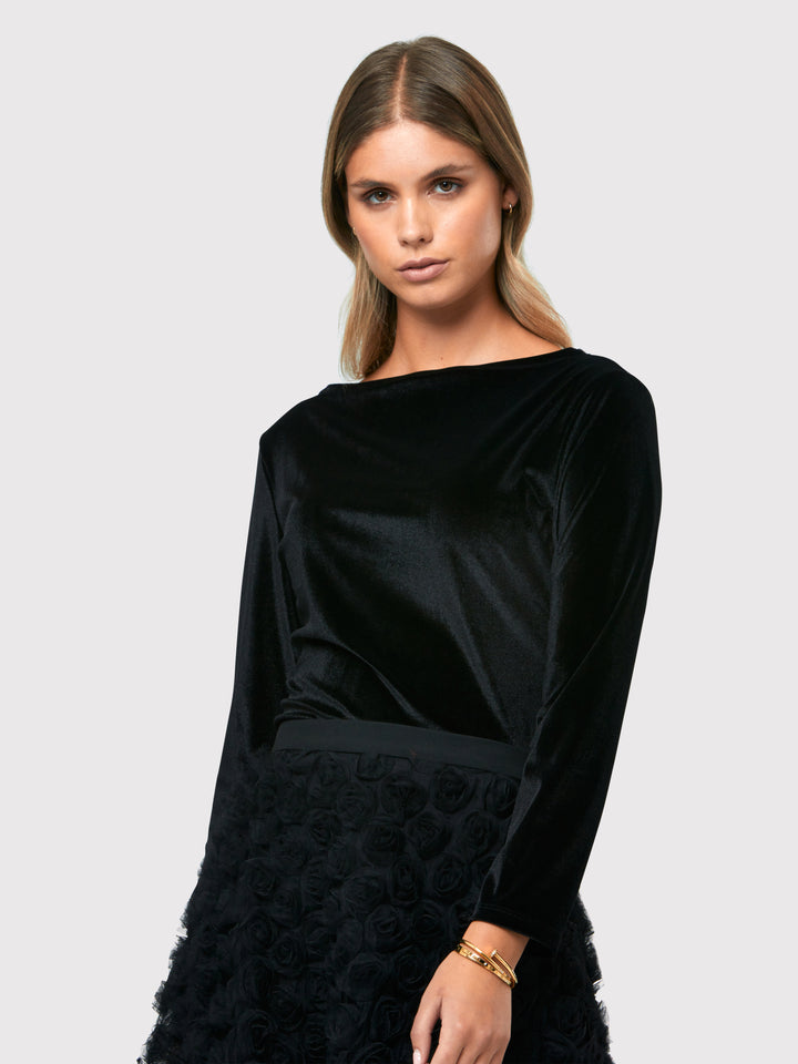 Teagan Black Velvet Top, a refined and stylish boat neck blouse that exudes sophistication. Crafted from sumptuous black stretch velvet, this top radiates opulence and elegance. Its timeless design makes it a versatile piece that can be effortlessly paired with various seperates.