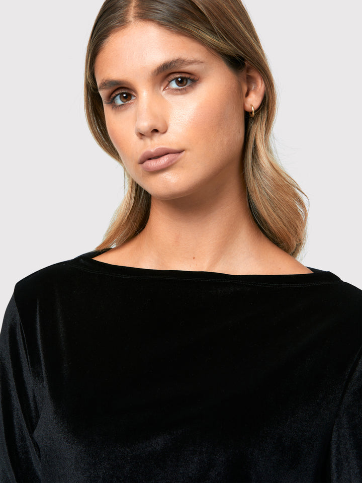 Teagan Black Velvet Top, a refined and stylish boat neck blouse that exudes sophistication. Crafted from sumptuous black stretch velvet, this top radiates opulence and elegance. Its timeless design makes it a versatile piece that can be effortlessly paired with various seperates.