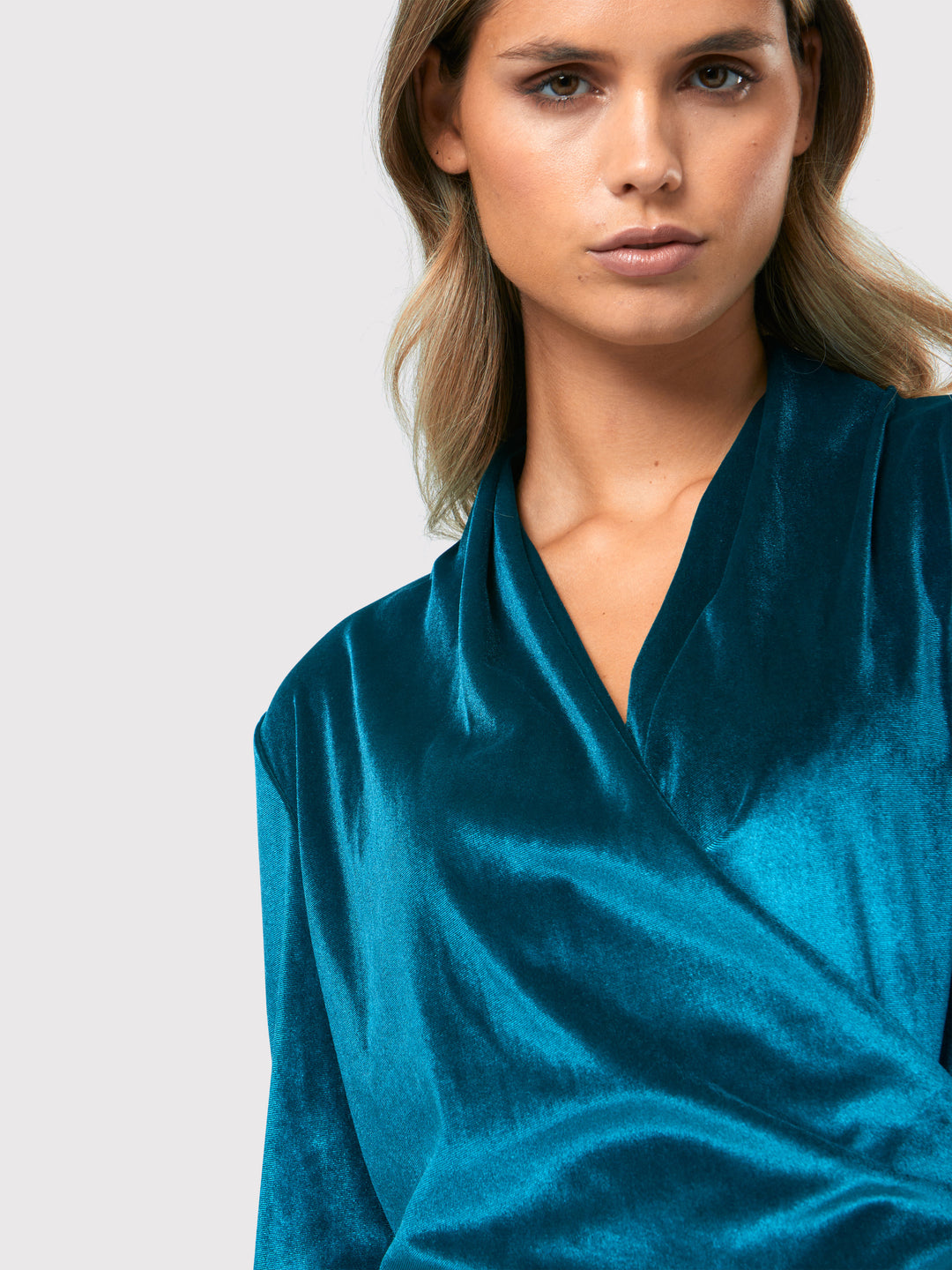 Introducing the Roxanne Petrol Top, an updated version of the beloved best-selling faux-wrap top. This stunning top showcases a sleek silhouette with a gracefully draped v-neckline, creating an air of elegance. Crafted from luxurious stretch velvet in a rich teal tone, it emanates sophistication and allure. The hip-length cut and full-length sleeves offer both comfort and style. Elevate your fashion game with the Roxanne Petrol Top, the epitome of refined chic and a statement piece for any occasion.
