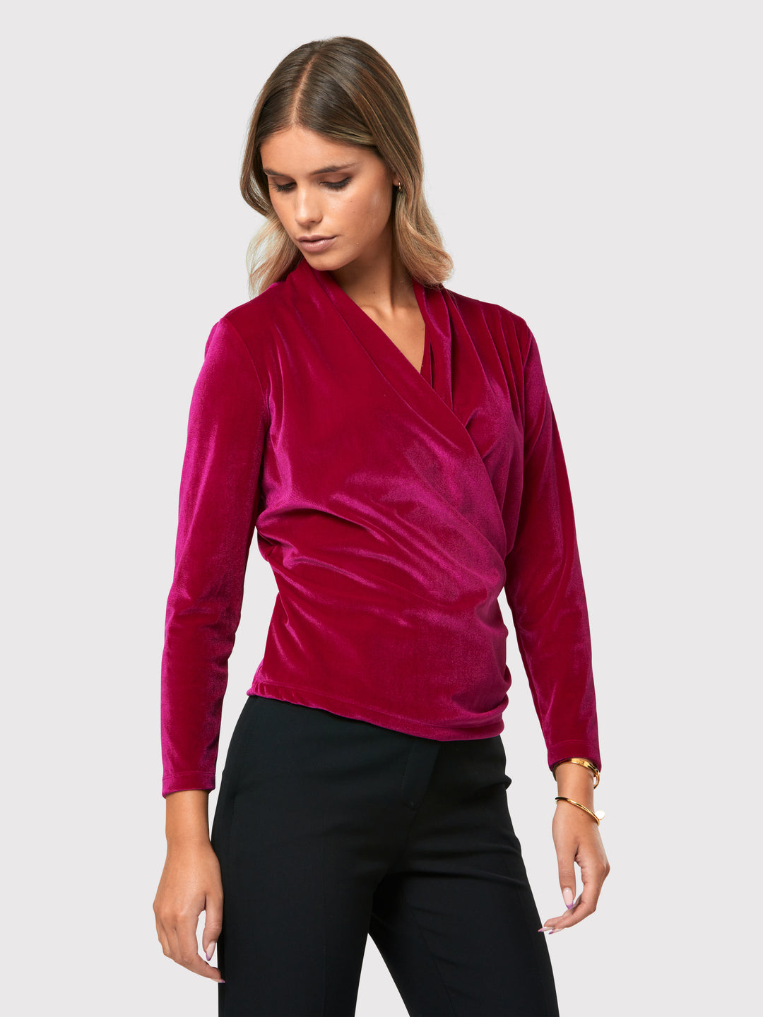 Introducing the Roxanne Fuchsia Velvet Top, an updated version of the beloved best-selling faux-wrap top. This captivating top boasts a sleek silhouette and a beautifully draped v-neckline, adding an elegant touch to your ensemble. Crafted from luxurious fuchsia stretch velvet, it radiates opulence and allure. With its hip-length cut and full-length sleeves, this top effortlessly combines comfort and style.