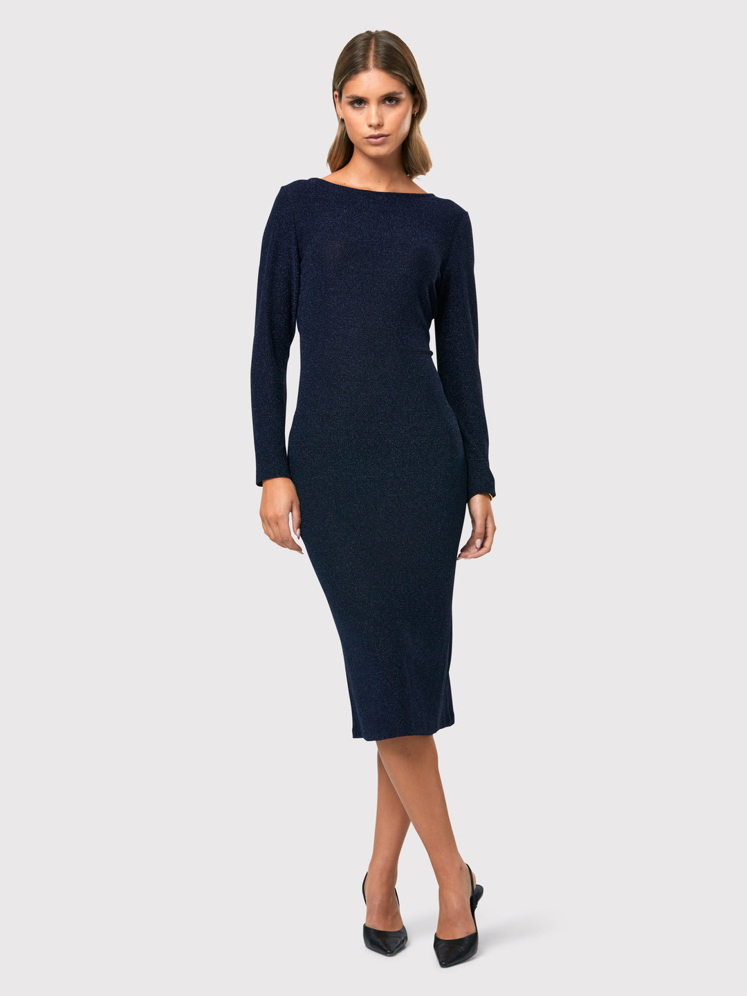 Introducing the Jamie Midnight Shimmer Dress, a captivating bodycon dress that exudes timeless elegance. This dress features super full-length sleeves, providing a sophisticated and chic look. Crafted from a sparkly navy jersey fabric, it adds a touch of glamour to your ensemble. The slash neck with a slight V-back detail adds a subtle hint of allure. 