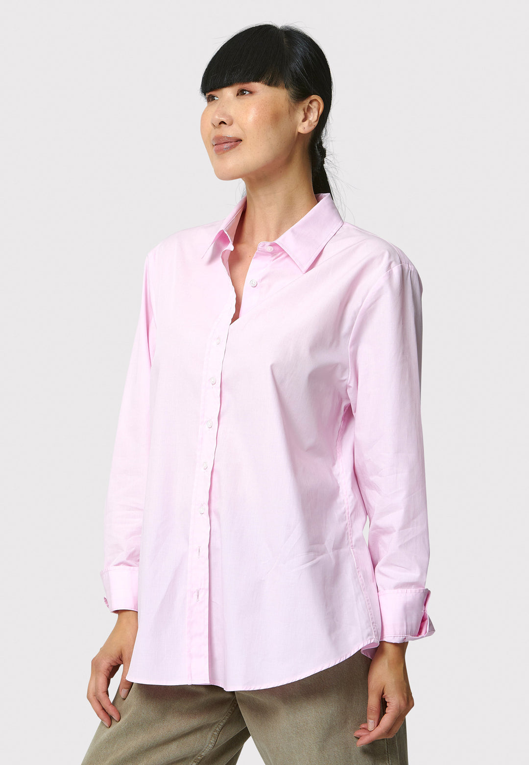 Woman wearing a light pink shirt against a white background