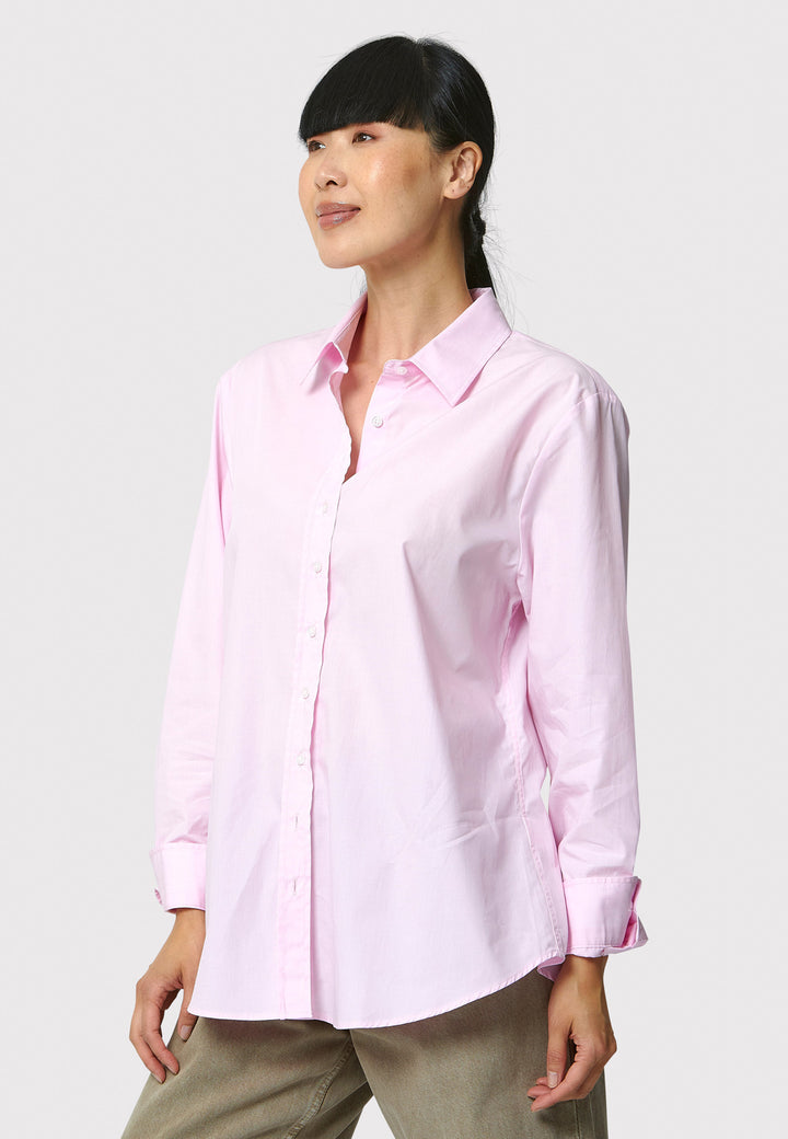 Woman wearing a light pink shirt against a white background