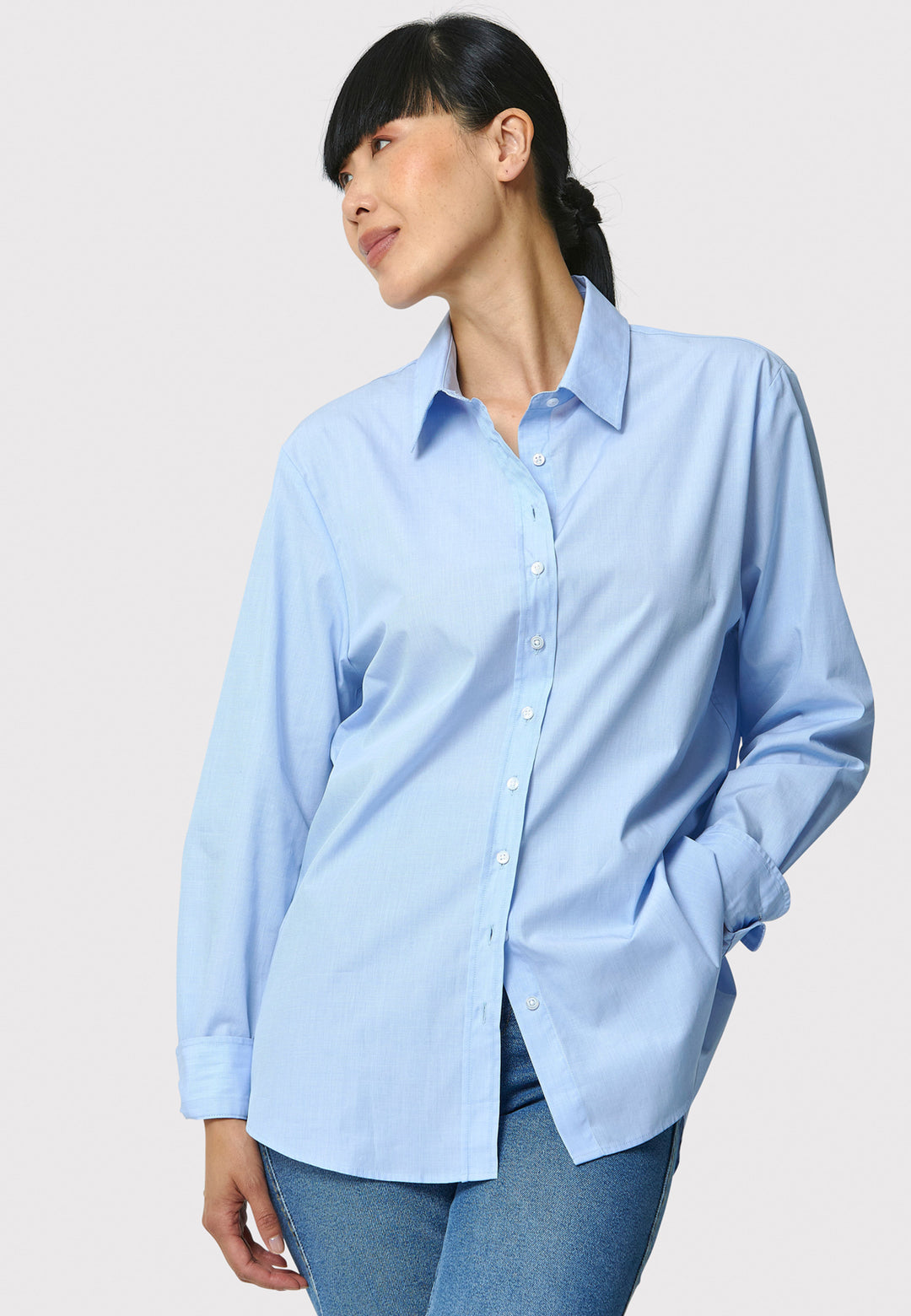 Woman wearing a light blue shirt against a plain background