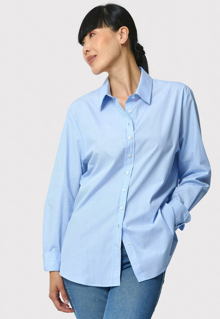 Woman wearing a light blue shirt against a plain background