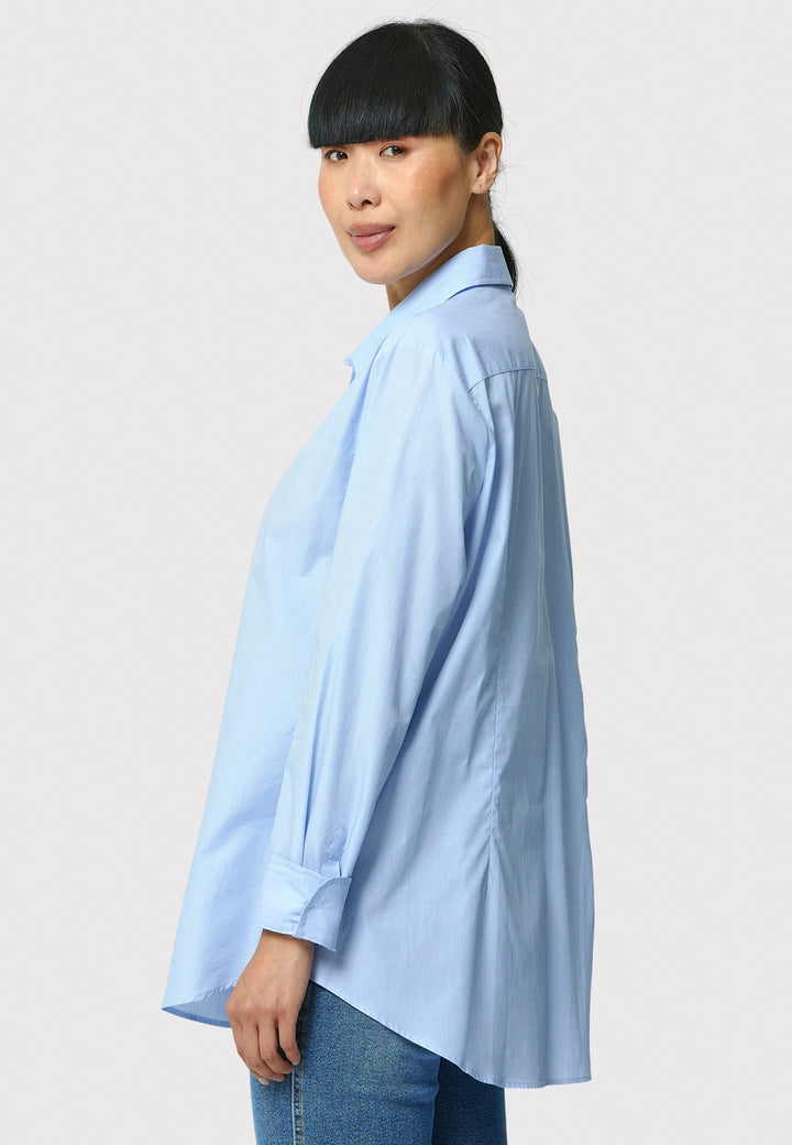 Woman wearing a light blue shirt against a plain background