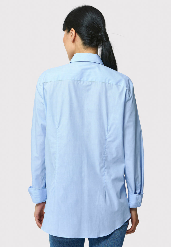 Person wearing a light blue shirt on a plain background