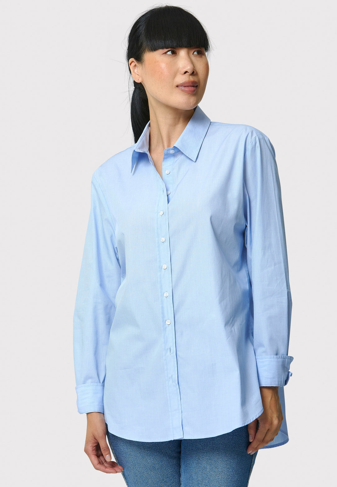 Woman wearing a light blue shirt against a plain background