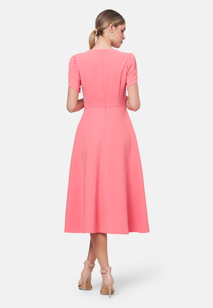 The Vera Poney Pink Dress is perfect for special occasions. It features a flattering fit-and-flare silhouette and short gathered sleeves with an elegant overlapping detail. The mid-calf length skirt flares out gracefully, adding elegance to the dress. Crafted from a comfortable fabric blend, it ensures ease of movement and a polished look.