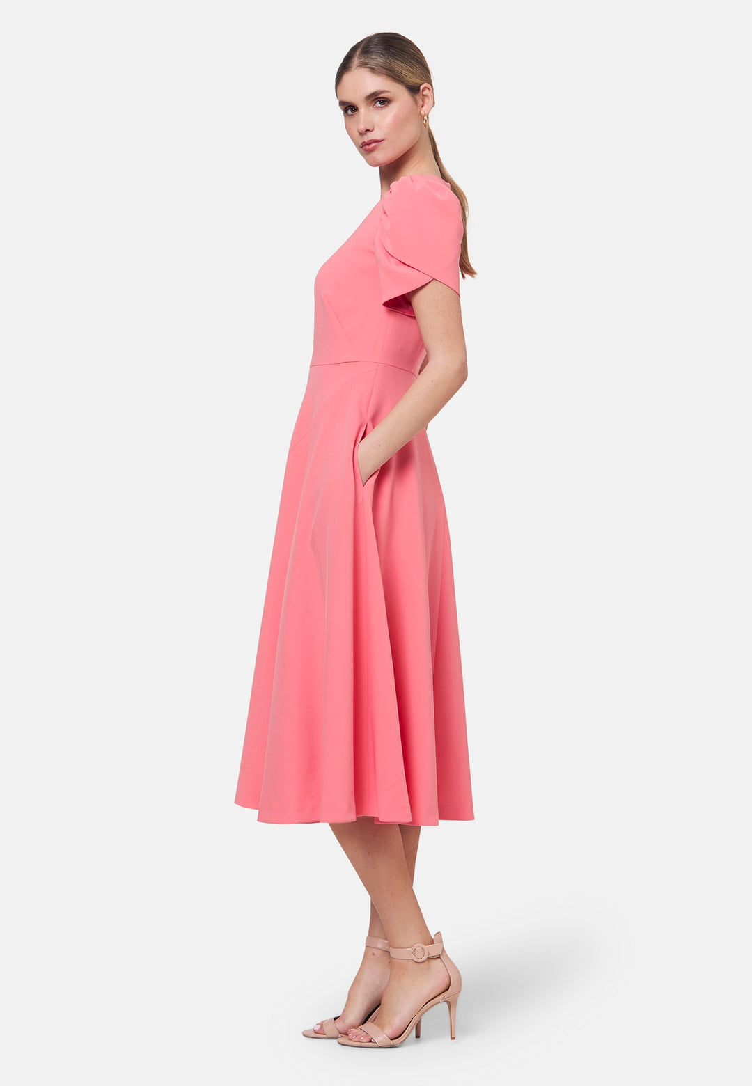 The Vera Poney Pink Dress is perfect for special occasions. It features a flattering fit-and-flare silhouette and short gathered sleeves with an elegant overlapping detail. The mid-calf length skirt flares out gracefully, adding elegance to the dress. Crafted from a comfortable fabric blend, it ensures ease of movement and a polished look.
