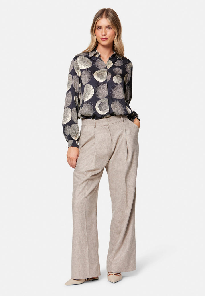 woman wearing printed navy and ivory shirt with wool pant
