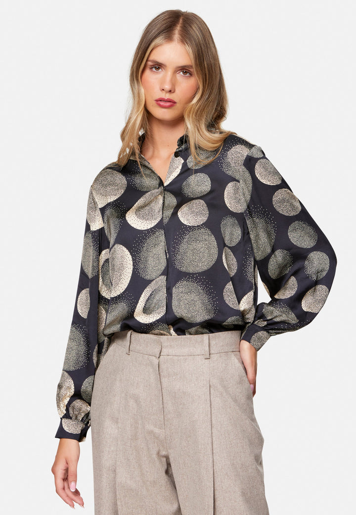 woman wearing printed navy and ivory shirt with wool pant