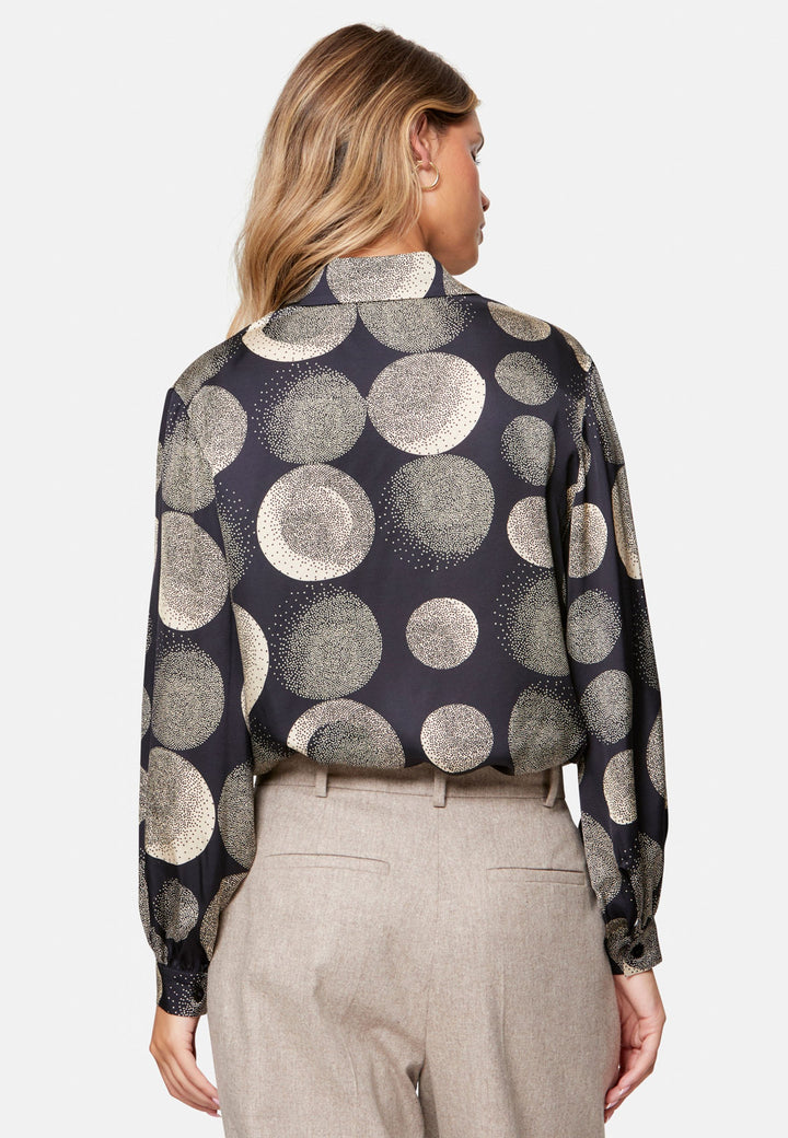 woman wearing printed navy and ivory shirt with wool pant