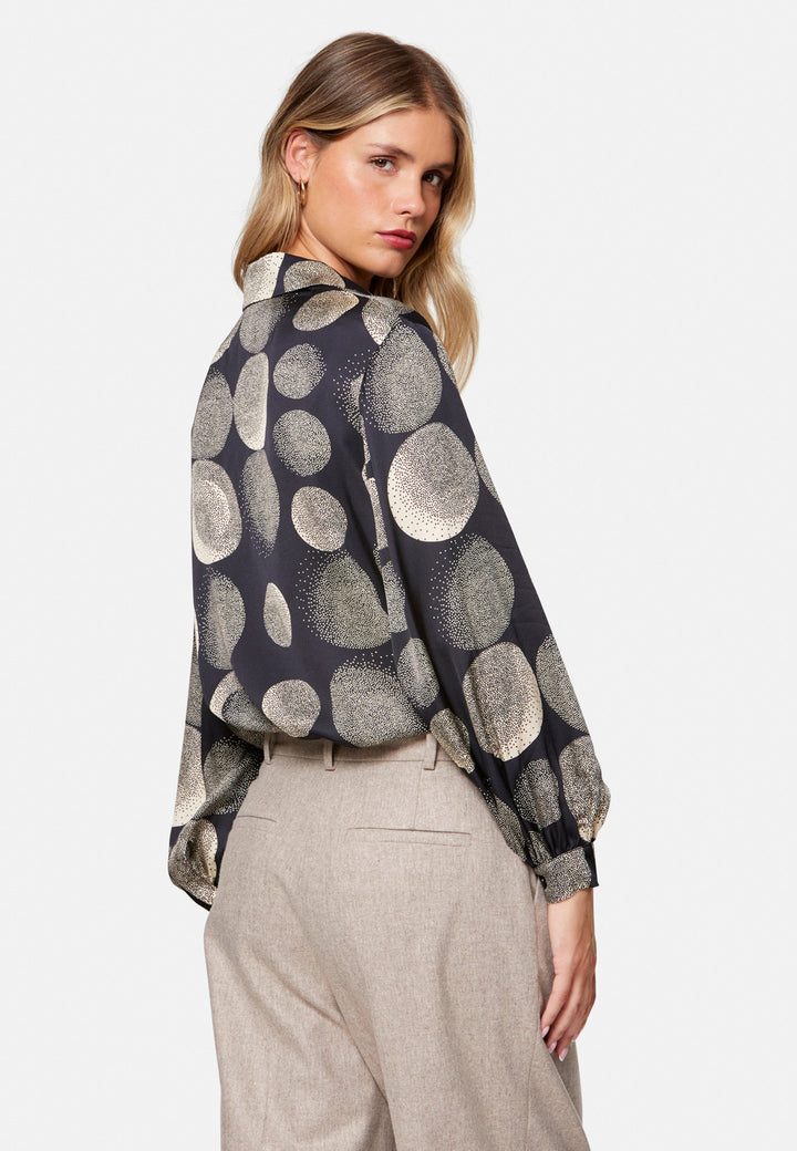 woman wearing printed navy and ivory shirt with wool pant