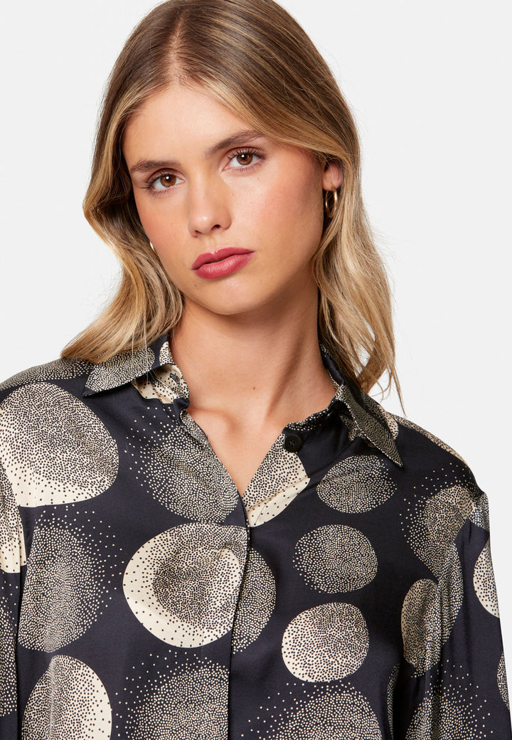 close up of woman wearing printed navy and ivory shirt