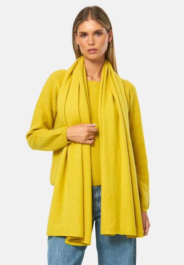 Knitted in pure cashmere with a soft handle, this generously cut wrap drapes fluidly. Loop, wrap or wear as a shoulder cover-up. It brings instant lift to denim days and casual outings. In vivid yellow ochre, it brightens winter neutrals; throw over a tailored coat or style with the coordinating knitwear for a cosy monotone look.