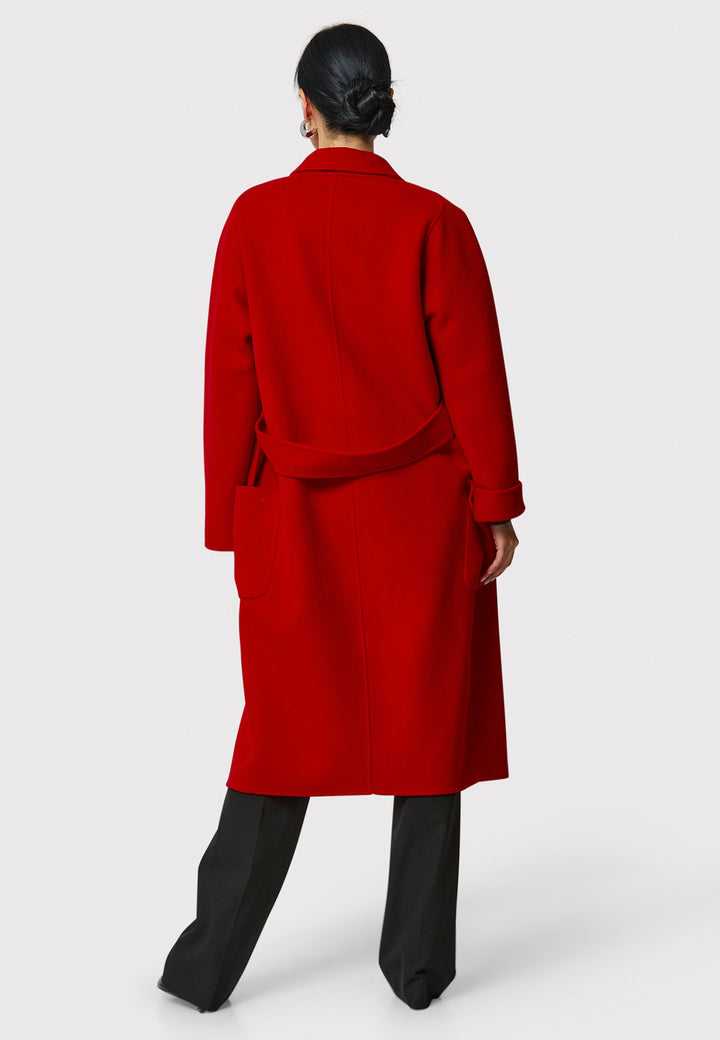 Introducing the Zola Cherry Red Cashmere Coat, a luxurious blend of cashmere and wool. This unlined coat features an oversized silhouette with patch pockets and a detachable belt. The dropped sleeves and tailor pick stitch finish add a touch of sophistication. Complete with a traditional collar and revere, it's a statement piece for your winter wardrobe.